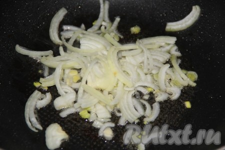 Переложить сосиски на тарелку, а в сковороду выложить очищенный и нарезанный на тонкие полукольца лук. Обжарить лук в течение 3 минут на среднем огне, иногда помешивая.
