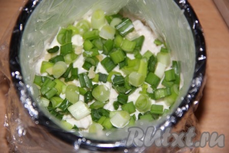 Вымыть, обсушить и нарезать зелёный лук. Половину нарезанного лука выложить следующим слоем. Слегка утрамбовывать слои салата.
