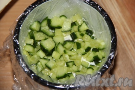 Свежий огурчик нарезать на кубики. Половину нарезанных огурцов выложить на слой белков.&nbsp;
