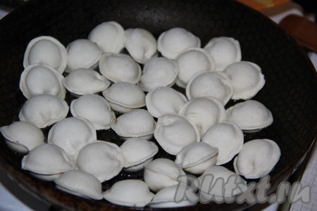 Замороженные пельмени выложить на сковороду, разогретую с растительным маслом.
