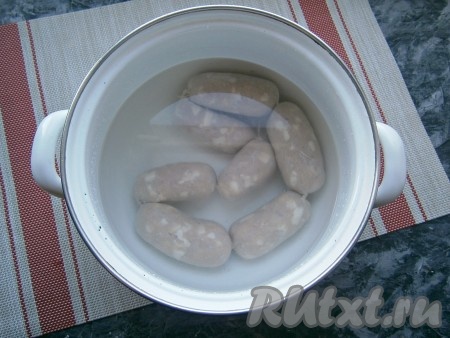 Затем шпикачки поместить в кастрюлю, залить полностью холодной водой.
