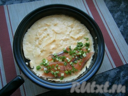 Жарить омлет, не накрывая крышкой, на среднем огне, серединку немного перемешивая лопаткой, до тех пор, пока верх не станет практически сухим, а низ омлета подрумянится (2-3 минуты). Затем на одну сторону омлета выложить тонкие ломтики слабосолёной сёмги и измельчённый зелёный лук.
