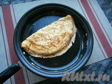 Сразу же, с помощью лопатки, накрыть рыбу второй половиной омлета и подержать на небольшом огне ещё около 1 минуты.
