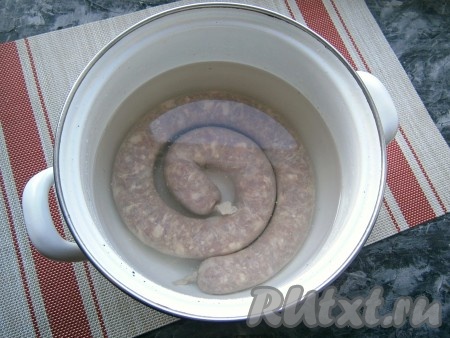 Тщательно перевязать концы кишок с двух сторон. Наколоть колбасу в нескольких местах иголкой, а затем поместить в кастрюлю, полностью залить холодной водой, поставить на огонь. После закипания воды, проварить домашнюю говяжью колбаску на медленном огне минут 10.
