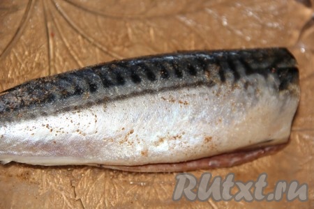 Скумбрию разморозить при комнатной температуре. Удалить голову, хвост и внутренности, не забывая убрать и чёрную плёночку из брюшка. Промыть скумбрию под водой, а затем обсушить бумажным полотенцем. Рыбку снаружи и внутри натереть солью и специями.
