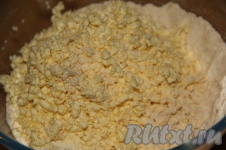Холодное сливочное масло натереть на тёрке (или порубить на кусочки) и всыпать в смесь сухих ингредиентов.
