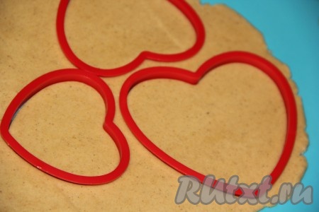 Раскатать каждую часть теста в пласт толщиной, примерно, 5 мм. С помощью вырубки для печенья вырезать сердечки.
