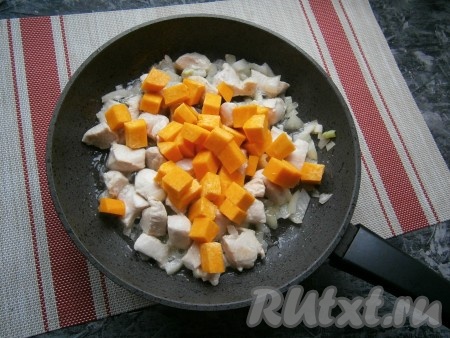 Обжаривать курицу с луком в течение 5 минут на среднем огне, не забывая иногда перемешивать. Когда мясо изменит цвет и только начнёт приобретать золотистый цвет, добавить в сковороду нарезанную средними кубиками мякоть тыквы.

