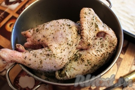 Чтобы крылья курицы не обгорали и не расправлялись в разные стороны во время запекания, нужно сделать проколы ножом в тушке и воткнуть в них кончики крыльев.
