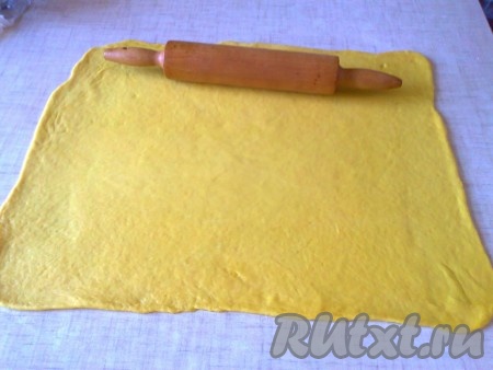 Затем, в зависимости от того, сколько куличей надо испечь, на столько частей разделите тесто. Можно испечь один большой кулич или два-три поменьше. Я готовила 1 большой кулич. Форма у меня диаметром 16 см. Присыпьте слегка рабочую поверхность и тесто мукой. Раскатайте тесто в очень тонкий прямоугольный пласт. Чем тоньше сможете раскатать, тем лучше.&nbsp;