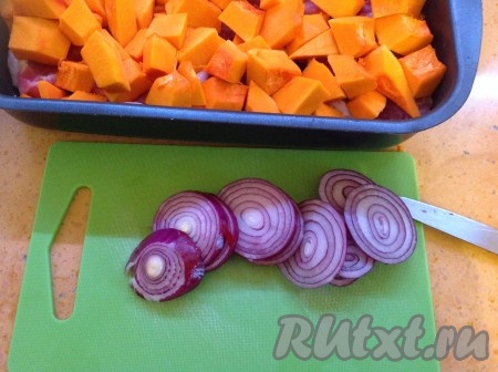 Очистить и нарезать лук кольцами и разложить сверху тыквы.
