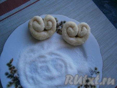 2 столовые ложки сахара смешать с ванильным сахаром, верх плюшек посыпать этой смесью, придавливая сахар.
