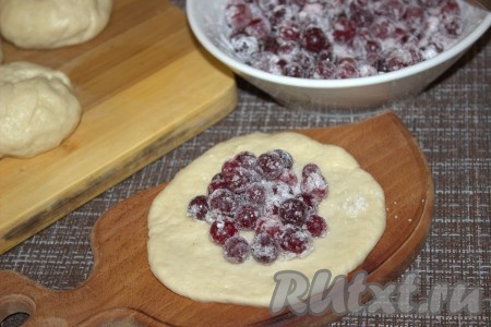 Каждый кусочек теста сначала скатать в "колобок", а затем расплющить в лепёшку. В середину каждой лепёшки выложить по 1-1,5 чайных ложки начинки из клюквы и сахара, затем тщательно защепить края, сформировав булочку.
