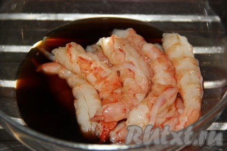 Удалить головы и очистить лангустинов, оставив только мясо. Промыть их под водой и переложить в миску. Залить лангустинов соевым соусом.
