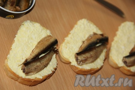 Выложить по две шпротинки на каждый бутерброд.
