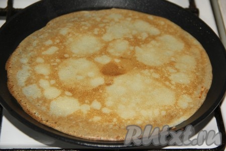 Жарить блин с двух сторон на среднем огне до золотистого цвета, а затем аккуратно переложить на тарелочку. Таким образом пожарить все блины, складывая их на тарелку один на другой.
