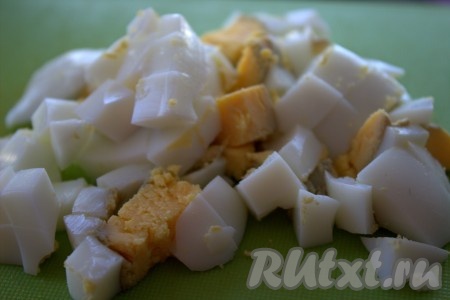 Отварить вкрутую 2 яйца (после закипания воды варить минут 10), затем охладить, очистить и нарезать на небольшие кубики.