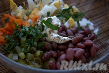 В миске соединить нарезанные морковь, яйца, петрушку (или другую зелень) и солёные огурчики, добавить консервированную фасоль, майонез, по вкусу посолить и поперчить, хорошо перемешать салат.