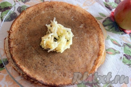 Яблоки очистить от кожуры и семечек, натереть на крупной тёрке. На корицу выложить, примерно, 1 столовую ложку с верхом натёртого яблока.
