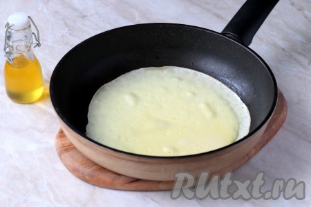 Сковороду разогреть и смазать тонким слоем растительного масла (делать это нужно только перед жаркой первого блина). Затем влить порцию теста, распределяя его равномерно по всему дну сковороды. 
