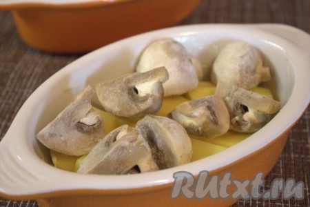 Если вы готовите со свежими шампиньонами, то их предварительно нужно промыть, очистить от грязи и нарезать на несколько частей. Если грибочки маленькие, разрезать их пополам, а крупные разделить ещё на несколько частей (я готовила с замороженными шампиньонами, разрезанными на 4 части). Поверх картошки выложить грибы и оставшийся лук.
