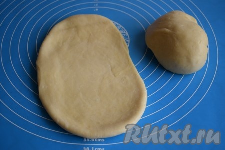 Делим тесто на 2 равные части. Одну часть теста убираем под плёнку, а вторую часть теста начинаем раскатывать в тонкий пласт.
