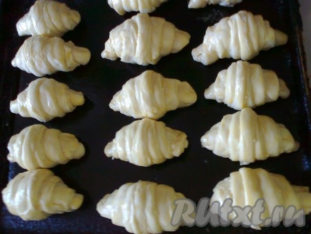 И оставьте на 20 минут для расстойки в тепле. Понадобится 2 противня. Смажьте верх круассанов желтком, смешанным с 1 чайной ложкой молока.