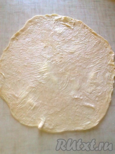 Смажьте круг теста размягчённым сливочным маслом с помощью кулинарной кисти.