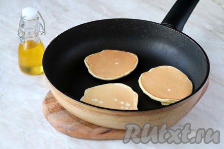 Жарьте панкейки на огне ниже среднего до появления пузырьков сверху, после чего с помощью деревянной лопатки переверните на другую сторону и готовьте до румяного цвета. Таким образом пожарьте все панкейки.
