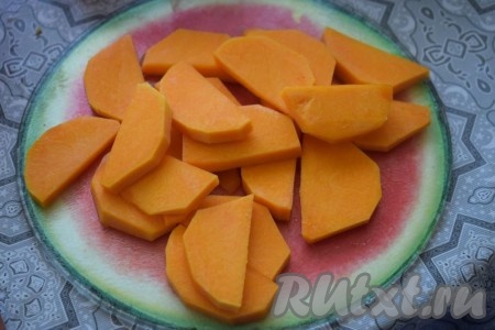 Очищенную тыкву нарежем на произвольные кусочки (я нарезала её на кружочки и затем кружки разделила пополам). Вместо тыквы можно взять морковь.
