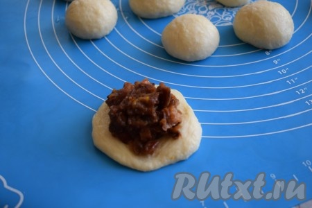 Затем расплющиваем каждый шарик рукой в лепёшку диаметром 8-10 см. На середину лепёшки кладём 1 столовую ложку начинки.

