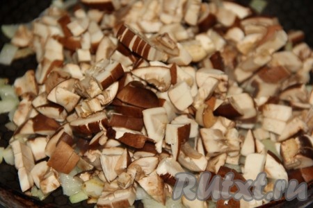 Если готовите с лесными грибами, тогда переберите их и заранее отварите в течение минут 25-30. Я готовила это блюдо с шампиньонами, их нужно просто промыть под водой и нарезать на пластинки. Нарезанные шампиньоны (или предварительно отваренные лесные грибы) добавить в сковороду к обжаренному луку.
