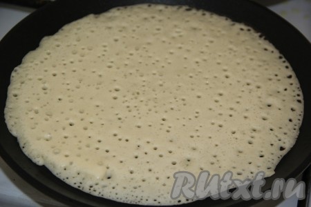 Часть теста вылить на хорошо разогретую блинную сковороду (я смазываю сковороду только перед жаркой первого блина), равномерно распределить и жарить блинчик до золотистого цвета с одной стороны на среднем огне.
