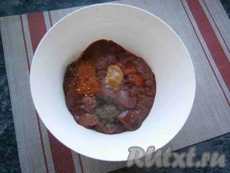 Куриную печень промыть в дуршлаге, дать воде полностью стечь, а затем немного обсушить и разрезать на 2 части.&nbsp; Добавить соль, перец, паприку, специи и горчицу, перемешать.
