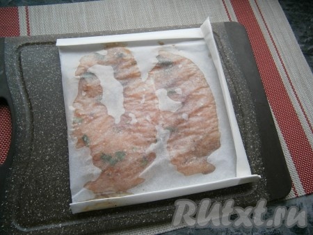 Завернуть пергамент конвертиком, сделав несколько подворотов (как на фото). В результате у нас получатся два конвертика из пергамента (в одном конвертике будет самое большое куриное филе, а в другом - два кусочка поменьше).
