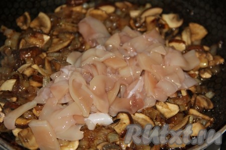 Нарезанные кальмары выложить в сковороду к обжаренным луку и грибам.
