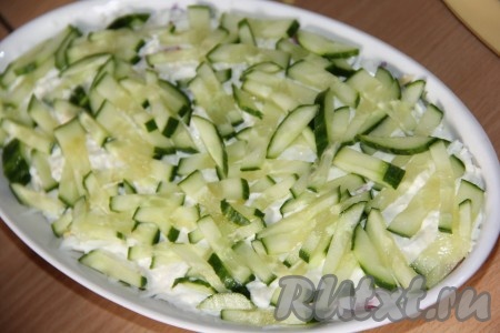 Огурец вымыть и нарезать на длинные брусочки. Часть огурца оставить для украшения (я оставила половину огурчика для украшения), отставший огурец выложить следующим слоем.
