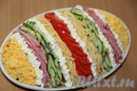 А теперь приступаем к оформлению салата "Елисейские поля". Выложить оставшиеся продукты ровными полосками. Между полосками можно сделать вставки из майонеза. Я выложила в следующей последовательности: желтки, майонез, колбаса, майонез, огурцы, сыр, майонез, помидоры, сыр, майонез, огурцы, колбаса, майонез, желтки. Дать салатику пару часов настояться в прохладном месте и подавать к столу.
