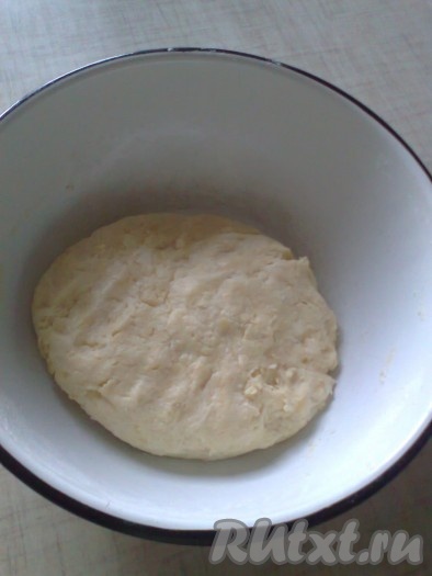 Добавляем грамм 150 просеянной муки с разрыхлителем, перемешиваем творожное тесто вначале ложкой, а после того как оно начнёт собираться в ком, продолжаем замешивать его руками, подсыпая по мере необходимости оставшуюся муку. Добавляя частями муку, обязательно учитываем, что главное, чтобы тесто собралось в липкий шар. Долго месить его не нужно. Муки может потребоваться как больше так и меньше, чем указано в ингредиентах, поэтому, как только собрали творожное тесто в липкий шар, значит больше муку добавлять не нужно. Миску с тестом накрываем пищевой плёнкой (или крышкой) и убираем на 30 минут в холодильник.
