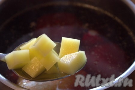 По прошествии 20-25 минут с начала варки курицы (с момента закипания бульона), достать мясо из бульона, дать курочке остыть, а затем отделить от костей. Сразу в куриный бульон, в котором продолжает вариться свекла, выложить нарезанную картошку.