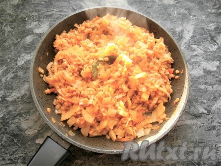 Всыпать сахар, перемешать, тушить капусту с перловкой на слабом огне под закрытой крышкой 30-35 минут. Через 10-15 минут с начала тушения добавить томатный соус (или кетчуп), а в конце тушения (за 5-7 минут до готовности) - лавровый листик и нарезанный чеснок.
