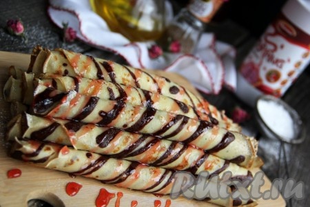 Жарить блин с двух сторон до золотистого цвета на среднем огне. Готовый блинчик переложить со сковородки на тарелку (я сразу сворачивала готовые блины в рулетик). Аналогично пожарить все полосатые блинчики. Вкусные, нежные, аппетитные блины подать к столу, полив сладким топпингом.
