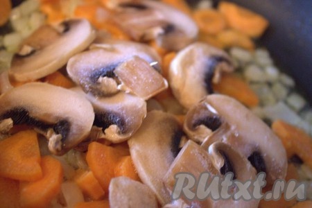 Шампиньоны вымыть, удаляя грязь, обсушить, нарезать на достаточно тонкие пластины (я использовала уже очищенные и нарезанные замороженные шампиньоны) и выложить в сковороду к луку и моркови, обжаривать на среднем огне, примерно, 7 минут, не забывая помешивать. В конце обжаривания немного посолить.
