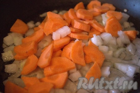 В сковороду, в которой обжаривалась гречневая крупа, влить растительное масло, выложить нарезанный лук, обжарить на среднем огне, помешивая, примерно, 1 минуту. В сковороду к луку выложить нарезанную морковь и обжаривать овощи, непрерывного помешивая, минут 5-7.
