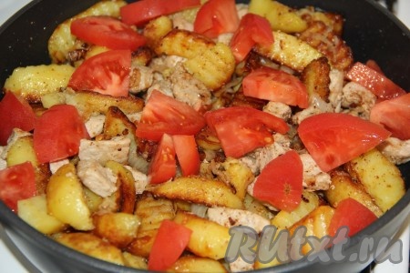 Помидоры вымыть и нарезать на дольки. Добавить помидоры в сковороду к мясу с картошкой, перемешать и потомить блюдо под крышкой на небольшом огне 5 минут. Помидоры дадут сок, но не станут мягкими.
