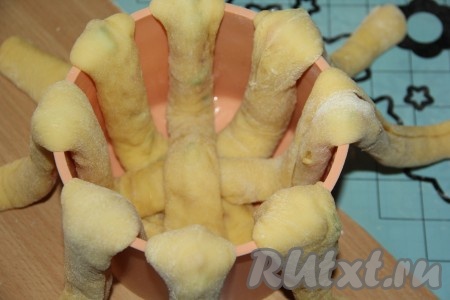 У меня силиконовая форма для кулича, я её не смазывала маслом. Если будете печь в железной, то обязательно смажьте форму маслом перед выкладыванием теста. Разрезать каждый жгут пополам. Выложить жгуты в форму крест-накрест, как лапки у паука.
