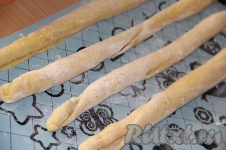 Свернуть каждый пласт теста с цукатами на столе в длинный жгут. У нас получатся 4 длинных жгута.
