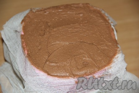 Переложить&nbsp;творожно-шоколадную массу в форму. Накрыть массу свисающими концами марли и поставить сверху гнёт (в качестве гнёта можно поставить поверх пасхи, накрытой марлей, небольшую тарелочку и банку с водой). Поставить форму с грузом в холодильник и оставить на 10-12 часов.