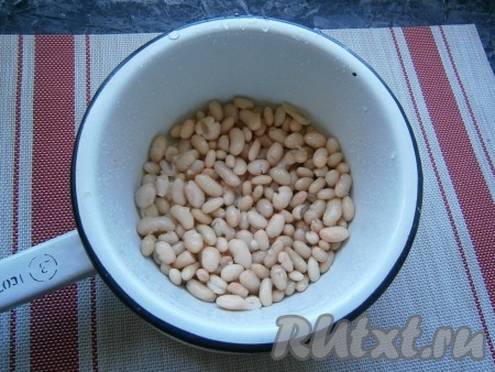 Если вы готовите это блюдо с сухой фасолью, тогда предварительно отварите её, для этого залейте фасоль холодной водой на ночь, затем залейте её чистой водой и отварите её с момента закипания на небольшом огне в течение 25-50 минут - в зависимости от сорта фасоли. Белая фасоль варится быстрее, поэтому лучше брать её. Варить фасоль нужно в несолёной воде, соль добавляется в конце варки. Отваренную фасоль откинуть на сито (или дуршлаг), чтобы стекла лишняя вода. Если вы готовите с консервированной фасолью, то её нужно промыть водой, используя дуршлаг, а затем дать стечь лишней жидкости.
