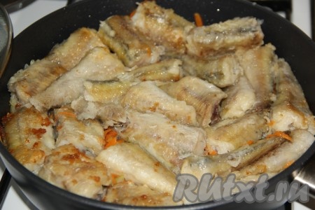 Затем разровнять обжаренные овощи и выложить кусочки минтая.
